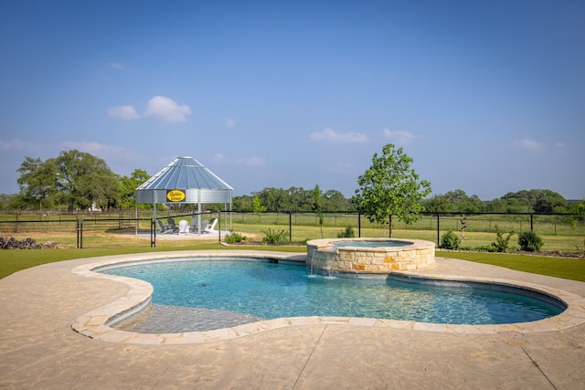 view of pool featuring a lawn, a gazebo, a patio area, pool water feature, and an in ground hot tub