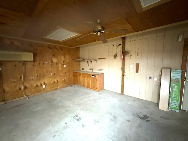 interior space featuring unfinished concrete floors, ceiling fan, and wood walls