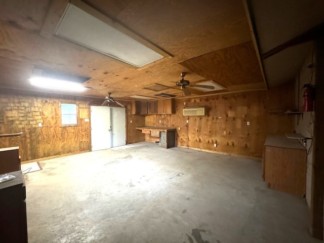 below grade area featuring ceiling fan and wood walls