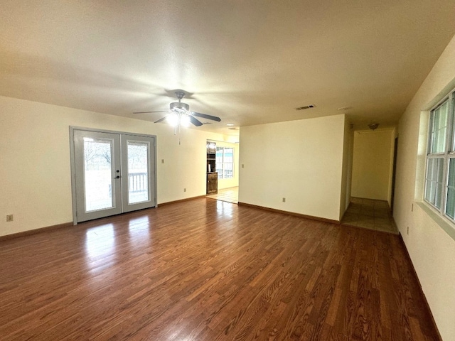 empty room with visible vents, wood finished floors, baseboards, french doors, and a ceiling fan