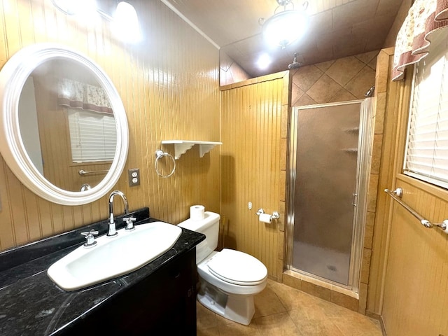 bathroom featuring tile patterned flooring, vanity, toilet, and a shower stall