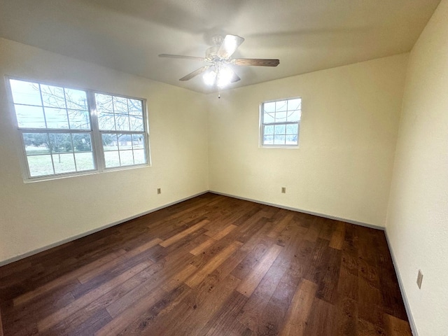 unfurnished room with baseboards, ceiling fan, and dark wood-style flooring