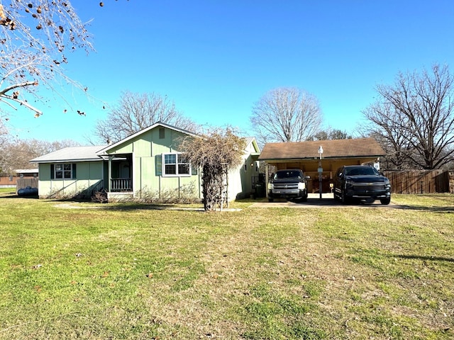 ranch-style home featuring fence, driveway, a front yard, and a carport