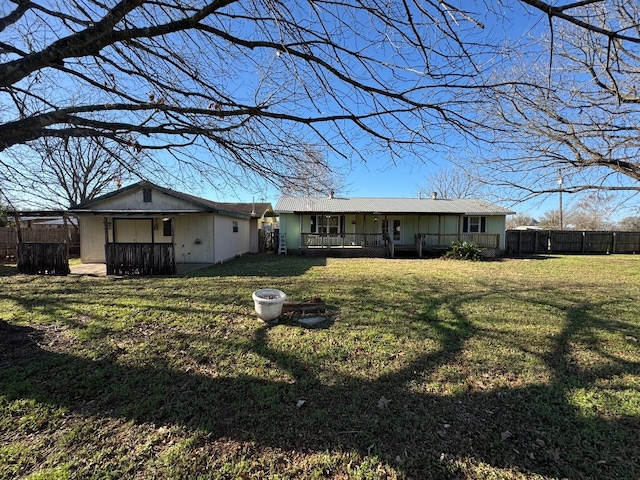 rear view of house with fence private yard, a yard, and a porch