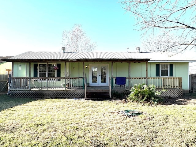 view of front of house featuring a front lawn, fence, french doors, metal roof, and a porch