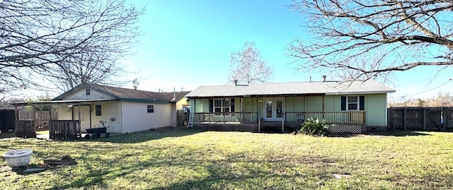 rear view of house with a yard, fence, board and batten siding, and a porch