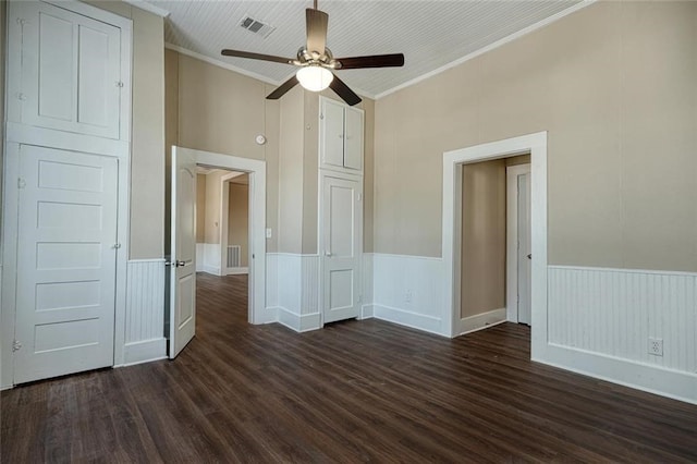 unfurnished bedroom with dark hardwood / wood-style flooring, ornamental molding, and ceiling fan