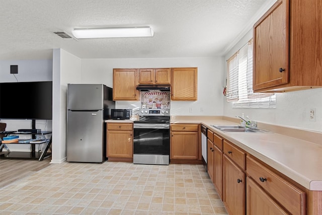 kitchen featuring sink, a textured ceiling, and appliances with stainless steel finishes