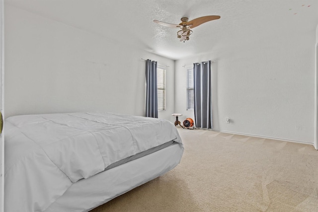 carpeted bedroom with a textured ceiling and ceiling fan