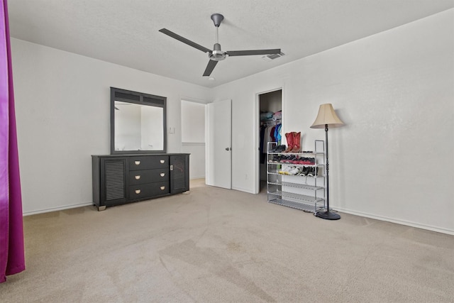 bedroom featuring light colored carpet, a textured ceiling, ceiling fan, and a closet