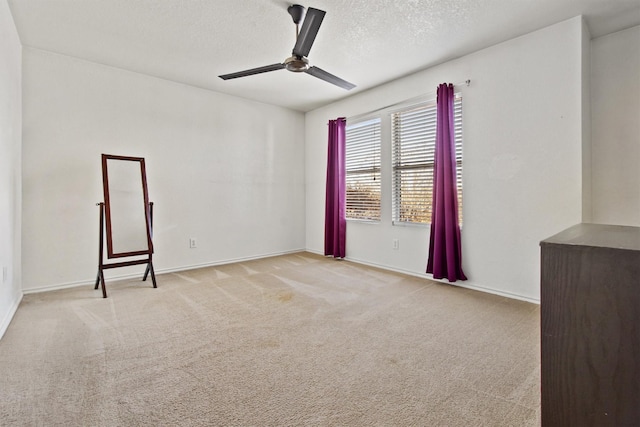 unfurnished room featuring light carpet, a textured ceiling, and ceiling fan