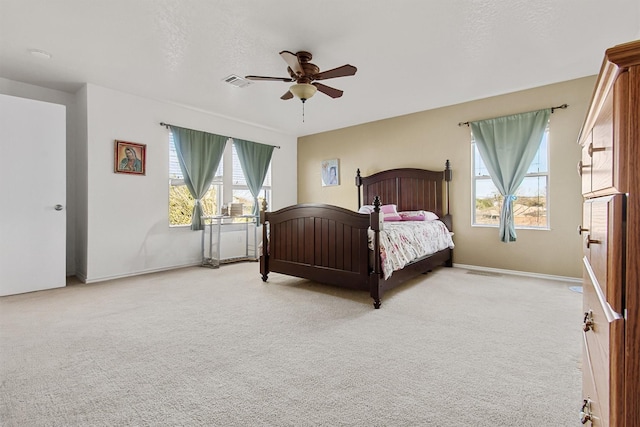 carpeted bedroom featuring multiple windows, a textured ceiling, and ceiling fan