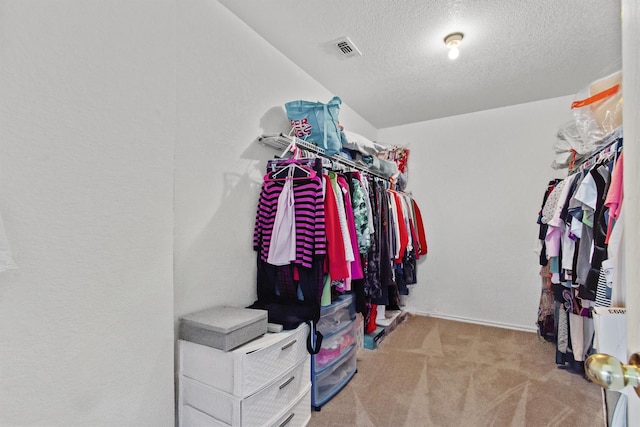 walk in closet featuring light colored carpet