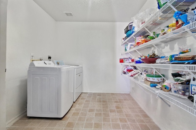 washroom featuring washer and dryer and a textured ceiling