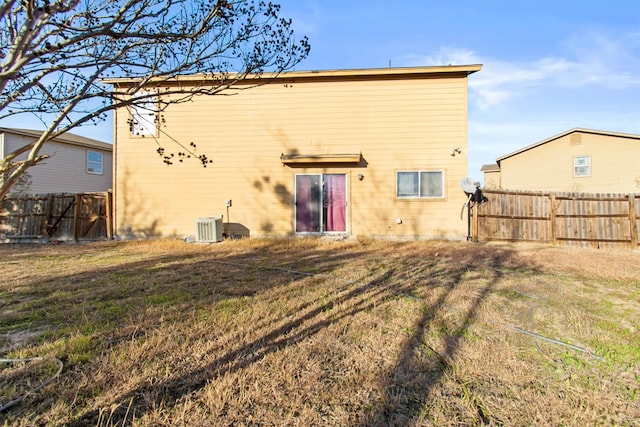 back of property featuring central AC and a yard