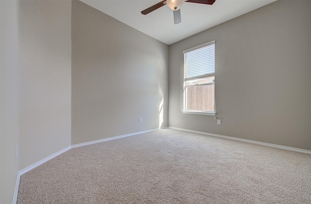 carpeted spare room featuring ceiling fan and vaulted ceiling