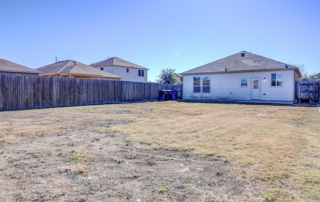 rear view of house featuring a yard