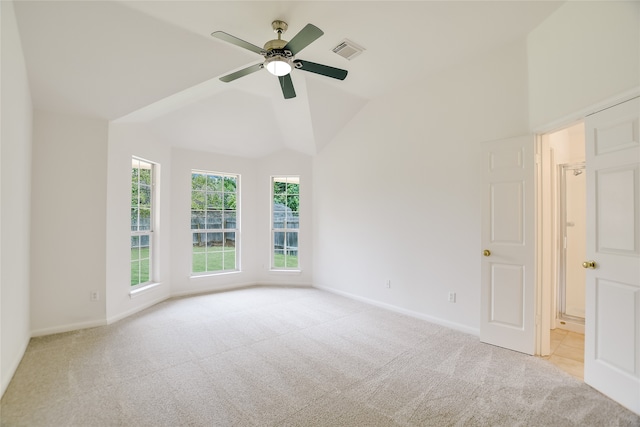 carpeted spare room featuring lofted ceiling and ceiling fan