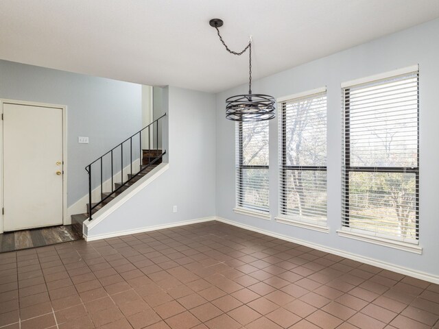 unfurnished dining area with stairway and baseboards