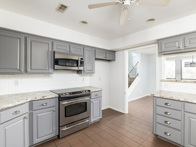 kitchen featuring visible vents, stainless steel appliances, backsplash, and gray cabinetry