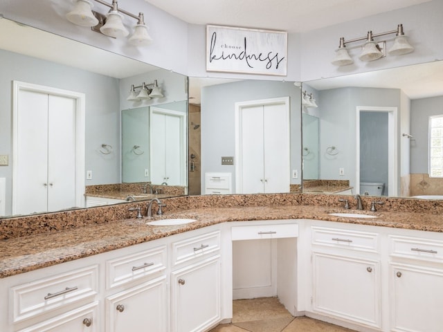 bathroom featuring tile patterned flooring, a sink, and double vanity