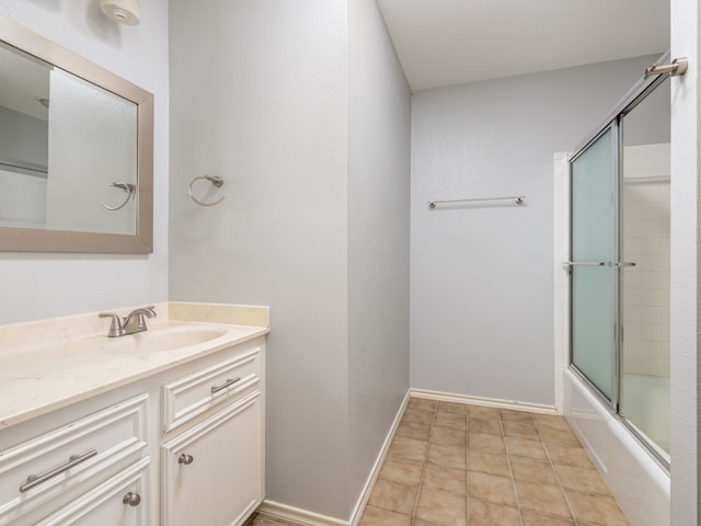 full bath with tile patterned floors, enclosed tub / shower combo, baseboards, and vanity