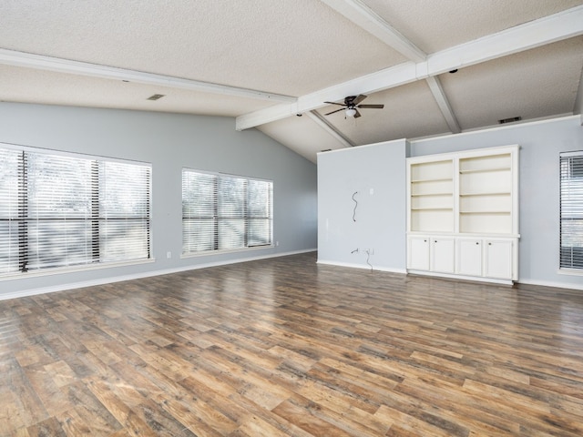 unfurnished living room with a textured ceiling, ceiling fan, vaulted ceiling with beams, wood finished floors, and baseboards