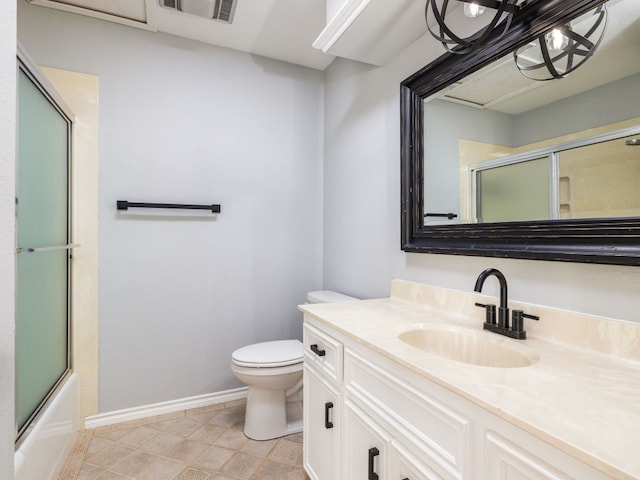 bathroom featuring toilet, visible vents, vanity, baseboards, and combined bath / shower with glass door