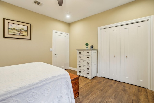 bedroom with ceiling fan, dark hardwood / wood-style flooring, and a closet