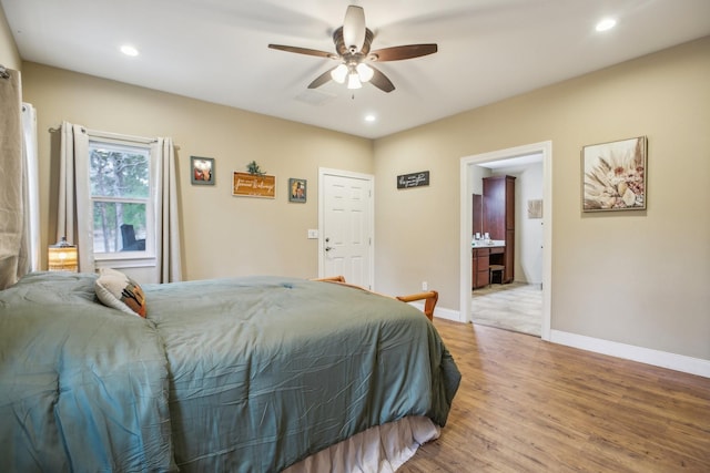 bedroom with ensuite bath, wood-type flooring, and ceiling fan