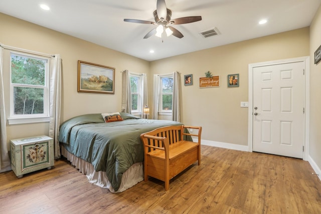 bedroom featuring multiple windows, ceiling fan, and light hardwood / wood-style floors