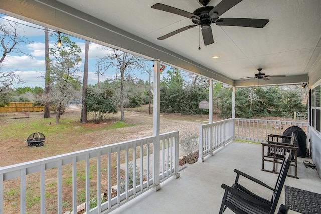 view of patio with ceiling fan, an outdoor fire pit, and covered porch