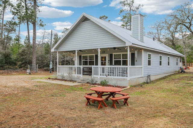 back of property featuring a lawn, ceiling fan, and a porch