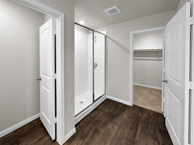 bathroom with hardwood / wood-style floors and an enclosed shower