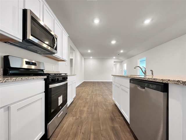 kitchen with light stone countertops, stainless steel appliances, dark hardwood / wood-style floors, and white cabinets