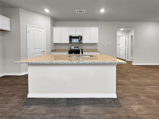 kitchen featuring white cabinetry, sink, a kitchen island with sink, and dark wood-type flooring