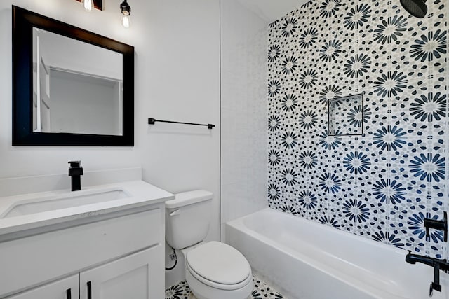 full bathroom featuring tiled shower / bath combo, vanity, and toilet