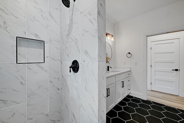 bathroom with vanity and a tile shower