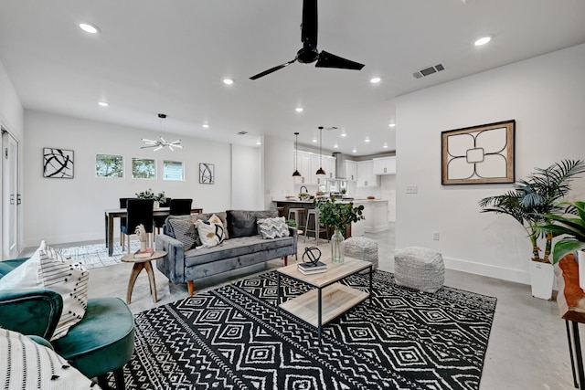 living room with ceiling fan and concrete flooring