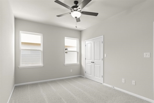 carpeted spare room featuring ceiling fan