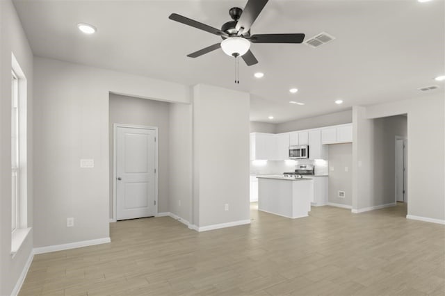 unfurnished living room featuring ceiling fan and light hardwood / wood-style flooring