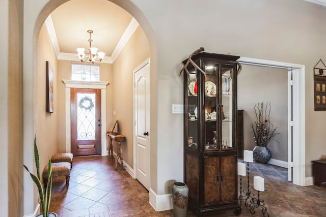 tiled entrance foyer featuring an inviting chandelier and ornamental molding