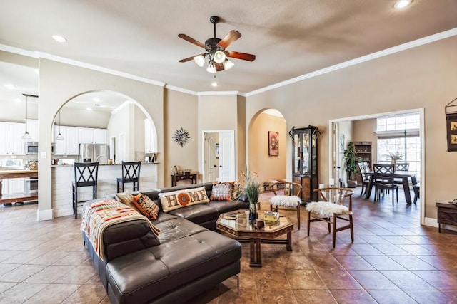 living room with tile patterned flooring, ornamental molding, and ceiling fan