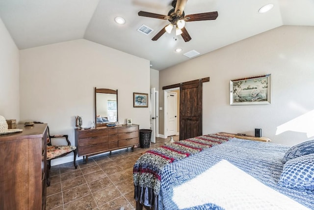 bedroom with ceiling fan, lofted ceiling, a barn door, and dark tile patterned floors