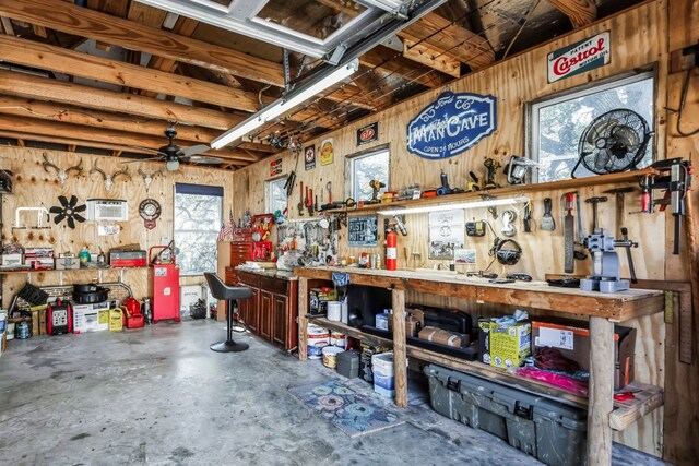 615 Mountain Crest Dr, Wimberley, TX 78676 - miscellaneous room with a workshop area, wood walls, unfinished concrete floors, and ceiling fan