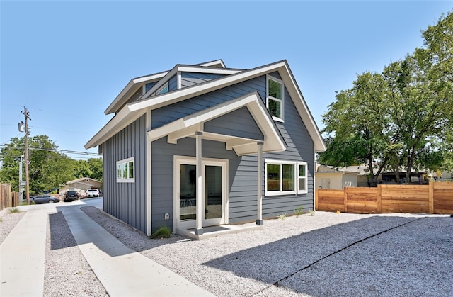 back of house with board and batten siding and fence