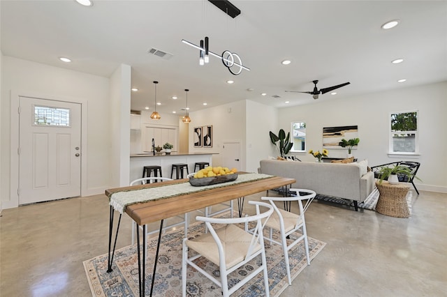 dining area with finished concrete floors, visible vents, and recessed lighting