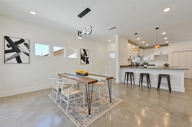 dining space with baseboards, recessed lighting, visible vents, and finished concrete floors