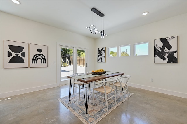 dining room with concrete floors, baseboards, and recessed lighting