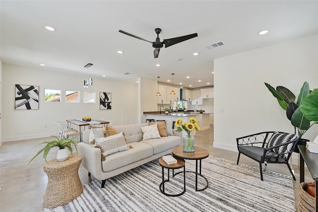 living room with concrete flooring, recessed lighting, visible vents, and baseboards